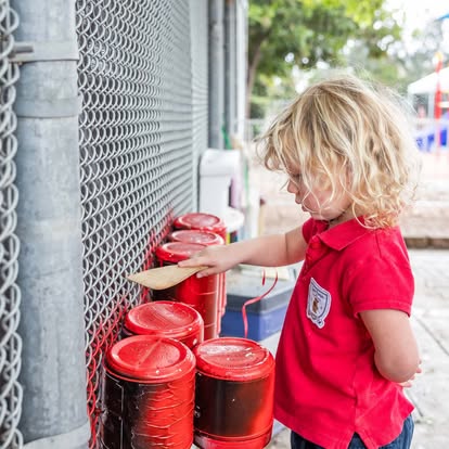 Niño de preescolar jugando con vasos de colores